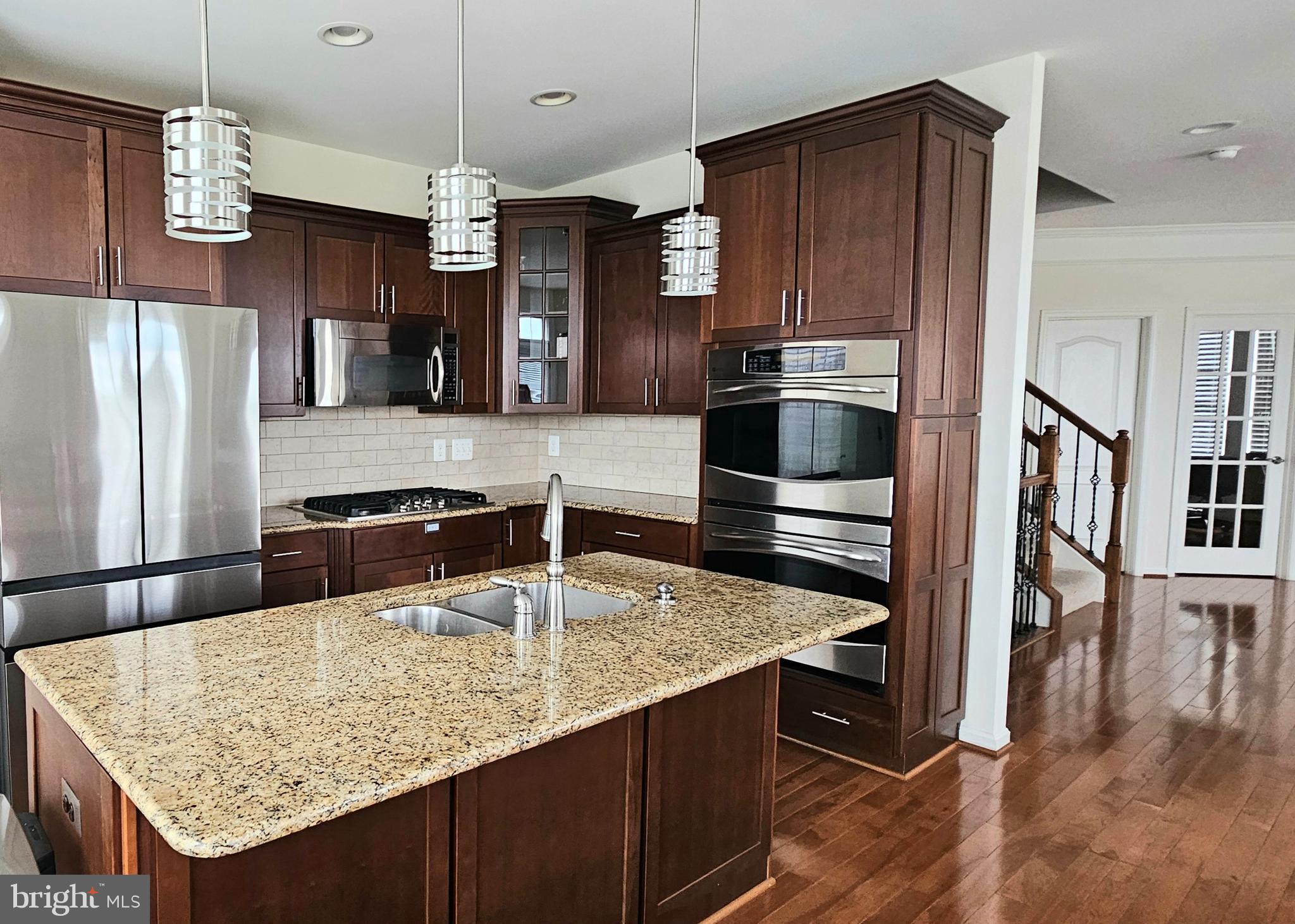 22629 Hawkbill Square Brambleton, VA 20148 - Photo 14 of 40 a kitchen with stainless steel appliances granite countertop a sink refrigerator and microwave