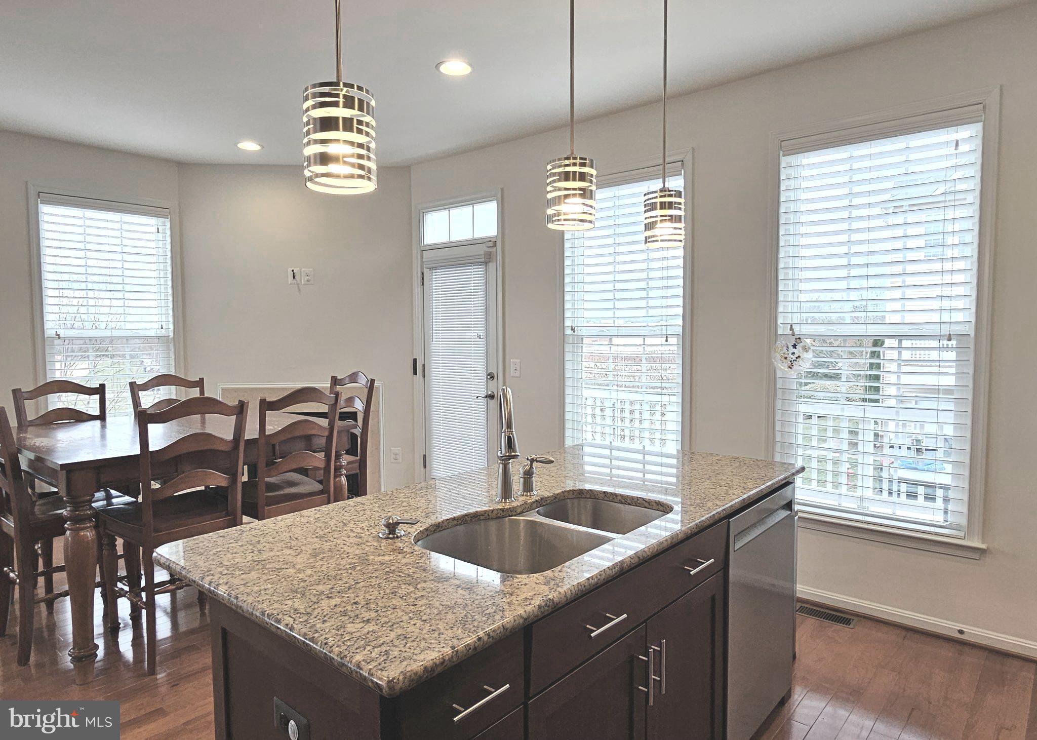 22629 Hawkbill Square Brambleton, VA 20148 - Photo 15 of 40 a kitchen with center island table and chairs
