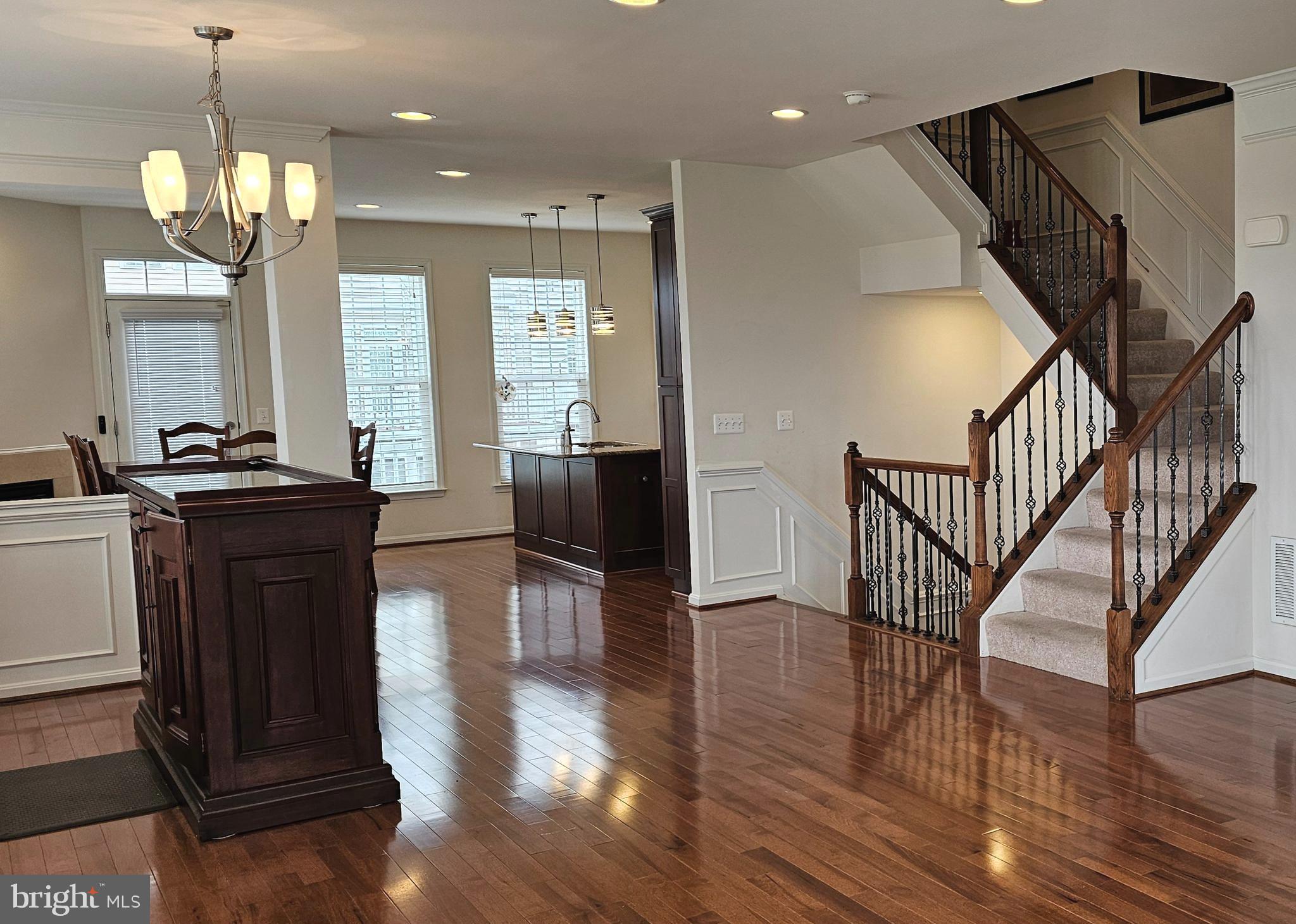 22629 Hawkbill Square Brambleton, VA 20148 - Photo 19 of 40 a view of a hallway with wooden floor and chandelier
