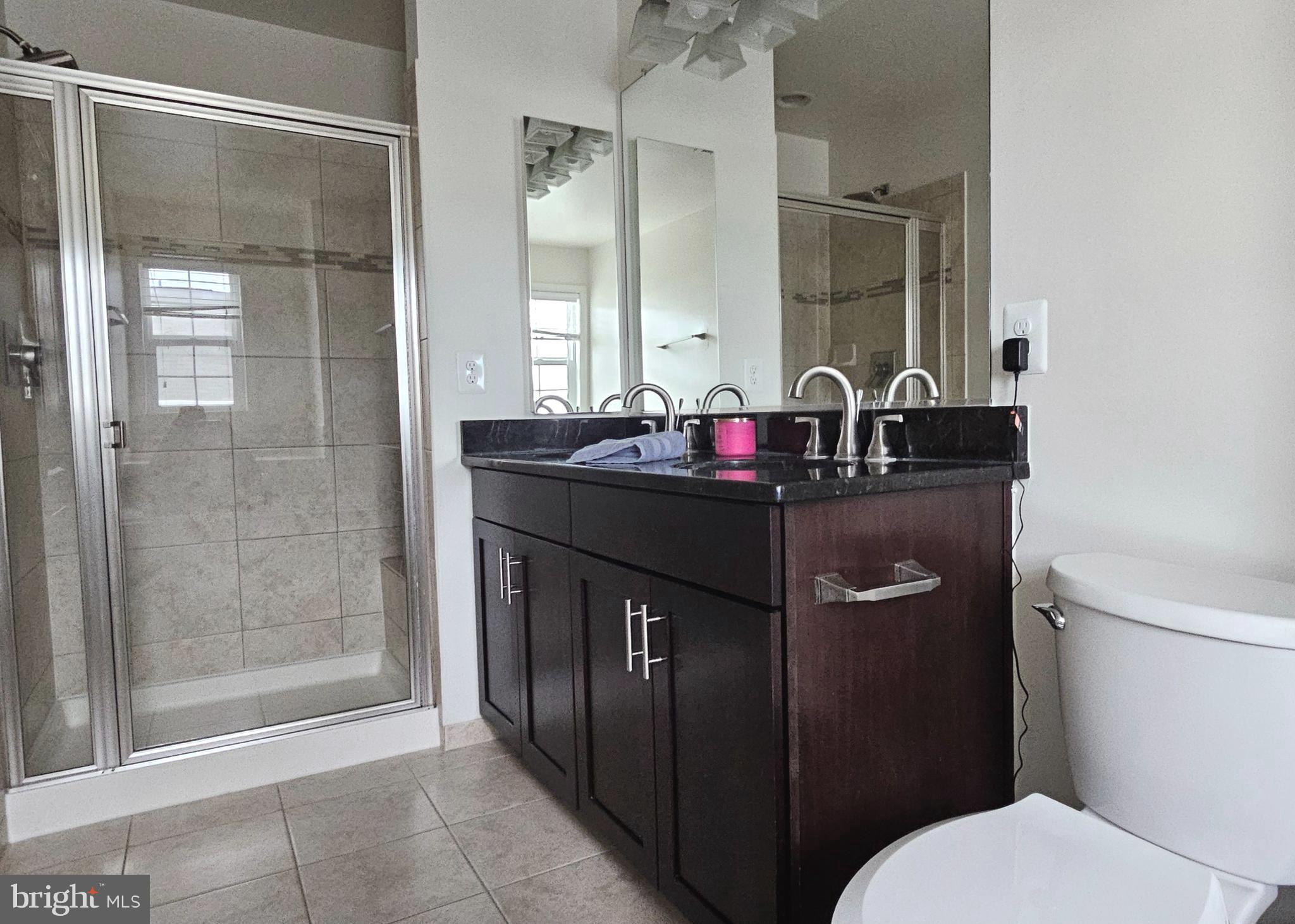 22629 Hawkbill Square Brambleton, VA 20148 - Photo 25 of 40 a bathroom with a granite countertop sink a toilet and a mirror