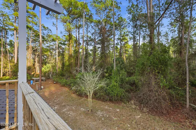 a view of balcony with wooden floor and trees