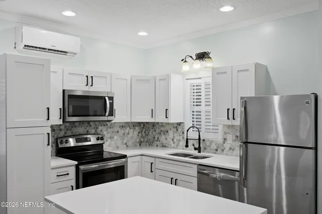 a kitchen with a refrigerator a microwave a sink and cabinets