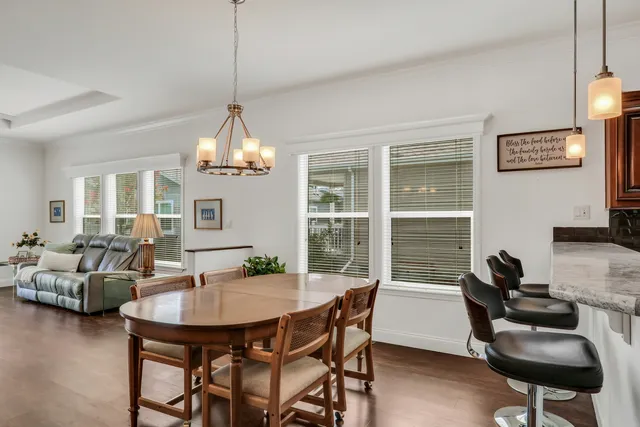 a view of a livingroom and dining room with furniture wooden floor and a chandelier