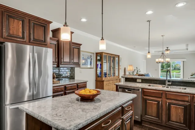 a kitchen with stainless steel appliances granite countertop a sink a stove and a refrigerator
