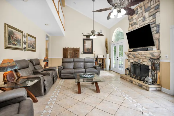 a living room with couches chairs and chandelier