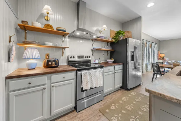 a kitchen with stainless steel appliances granite countertop a sink a stove and a refrigerator