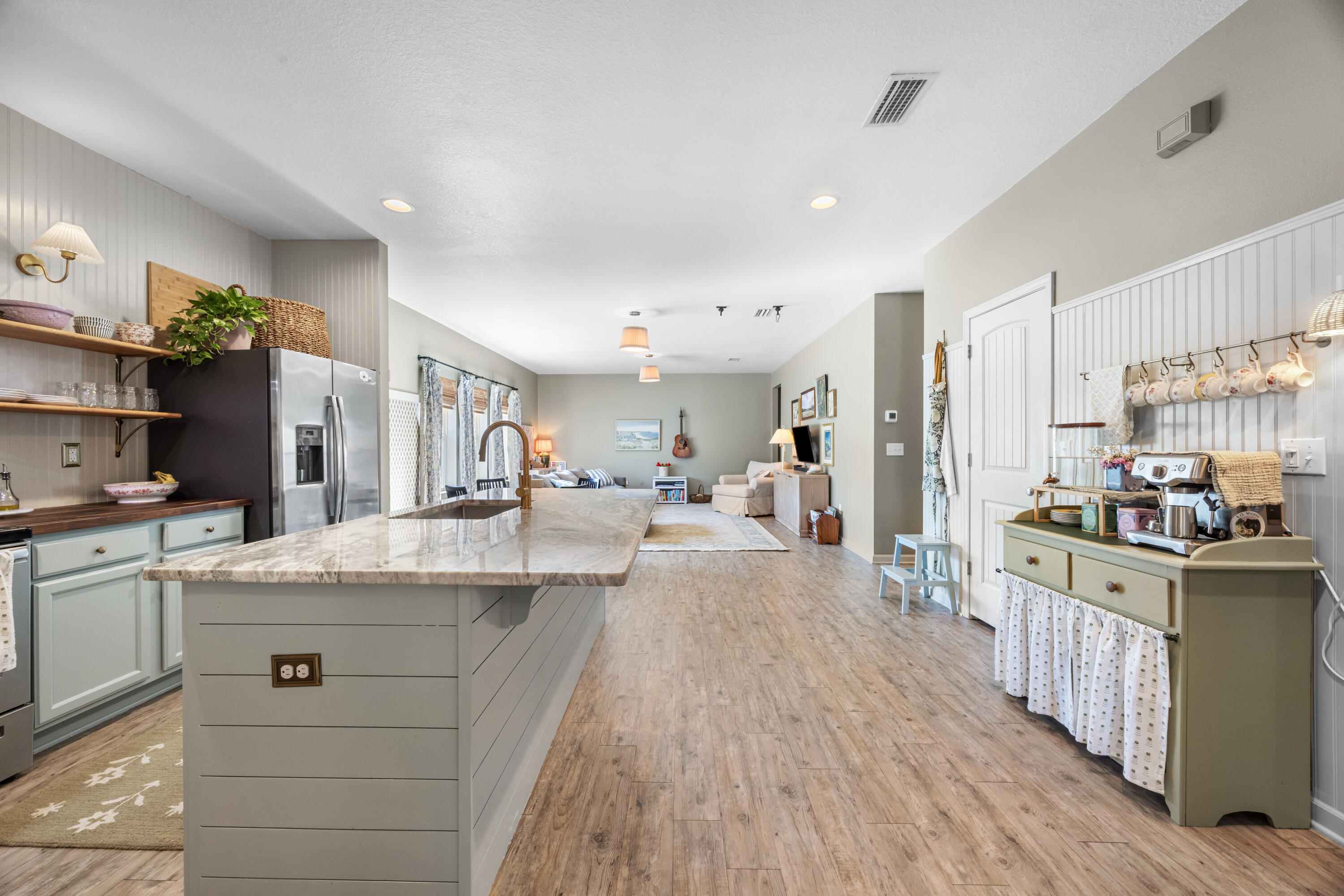 110 Cornelia Street Freeport, FL 32439 - Photo 12 of 60 a kitchen with stainless steel appliances kitchen island granite countertop a stove a sink a refrigerator and white cabinets with wooden floor