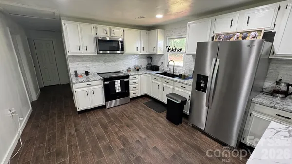 a kitchen with stainless steel appliances a refrigerator sink and wooden cabinets