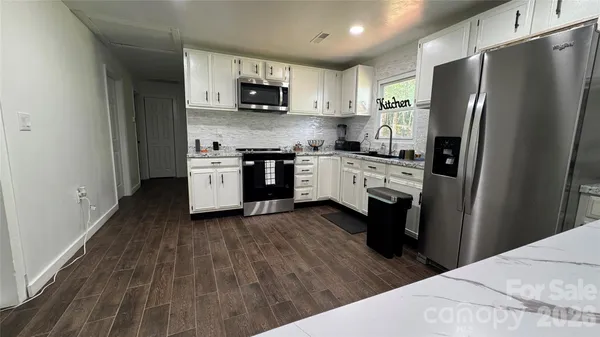 a kitchen with stainless steel appliances a refrigerator stove microwave and sink