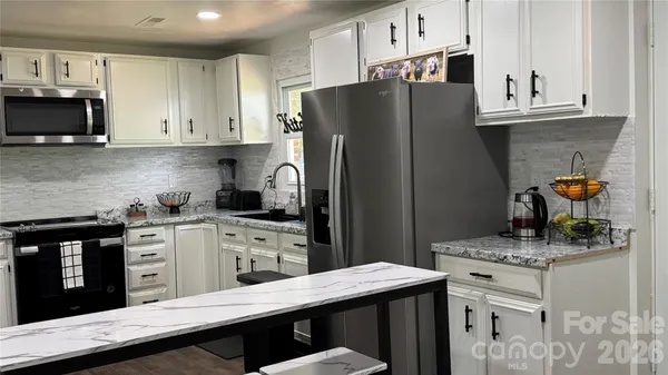 a kitchen with stainless steel appliances a stove refrigerator sink and cabinets