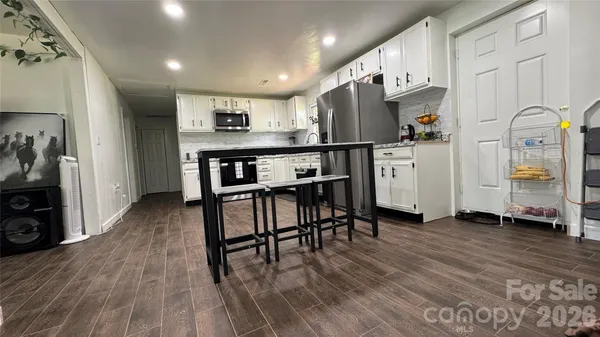 a view of a kitchen with furniture and wooden floor