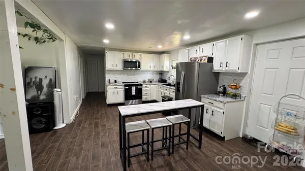 a kitchen with refrigerator cabinets and wooden floor