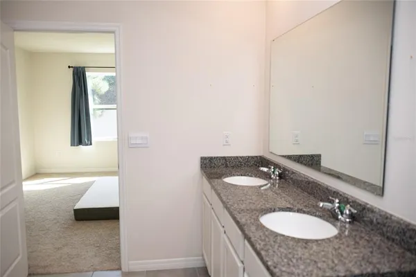 a bathroom with a granite countertop sink and a mirror