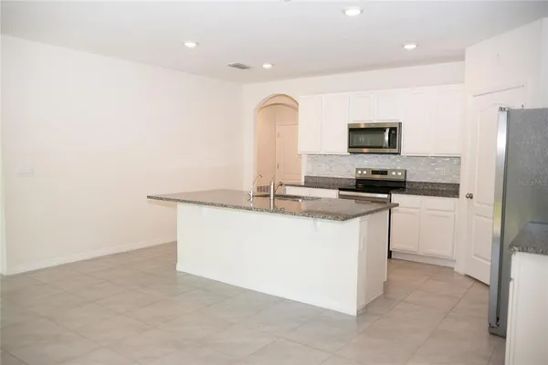 a kitchen with kitchen island a sink stainless steel appliances and window