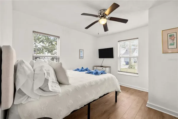 a bedroom with a bed a window and a flat screen tv