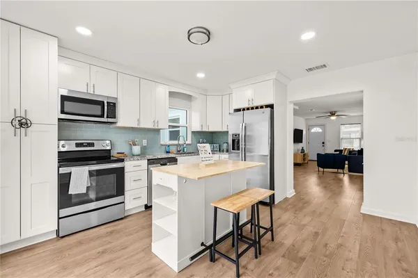 a kitchen with a refrigerator a stove top oven a sink dishwasher and wooden cabinets