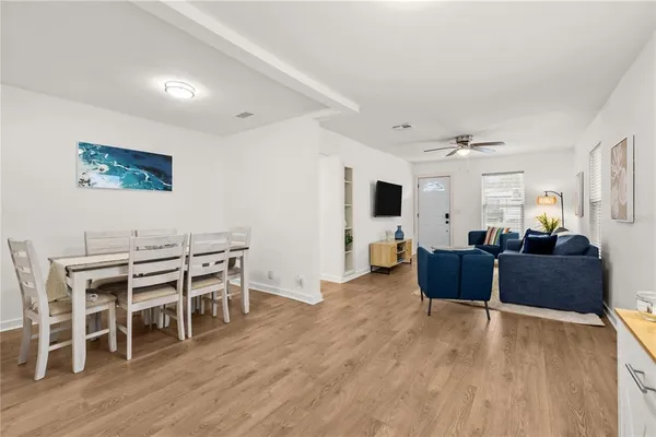 a living room with furniture a dining table and wooden floor