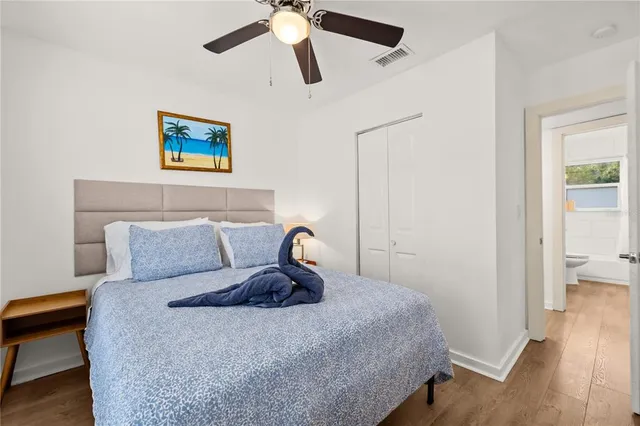 a bedroom with a bed and wooden floor