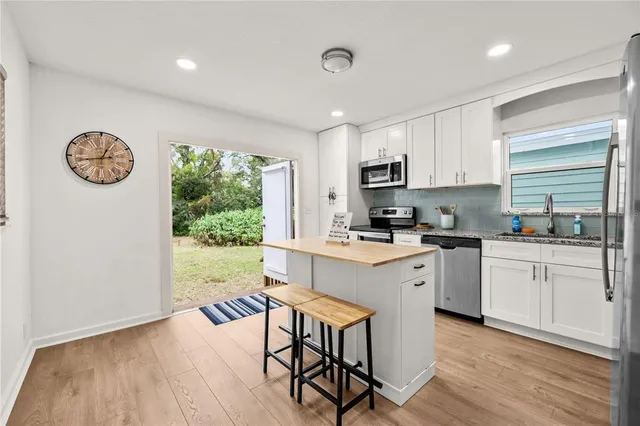 a kitchen with a table chairs microwave and cabinets