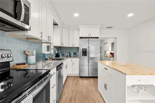 a kitchen with stainless steel appliances granite countertop a sink stove and refrigerator