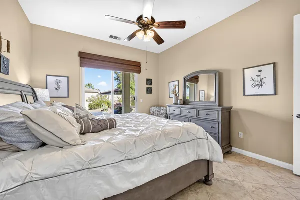 a bedroom with a bed ceiling fan and a window