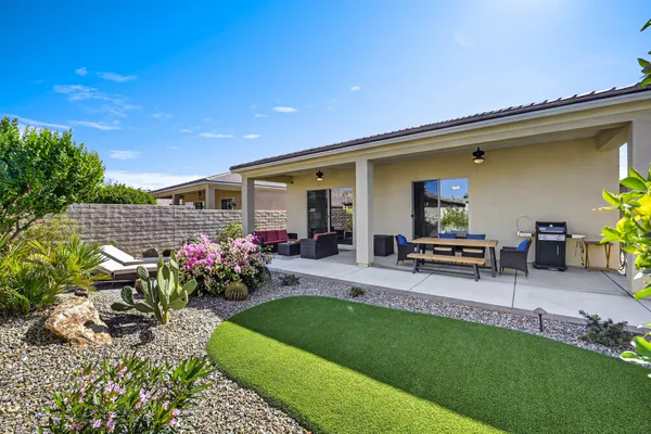 a view of house with backyard and outdoor seating