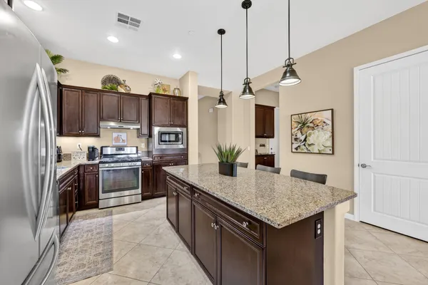 a kitchen with stainless steel appliances granite countertop a sink refrigerator and cabinets