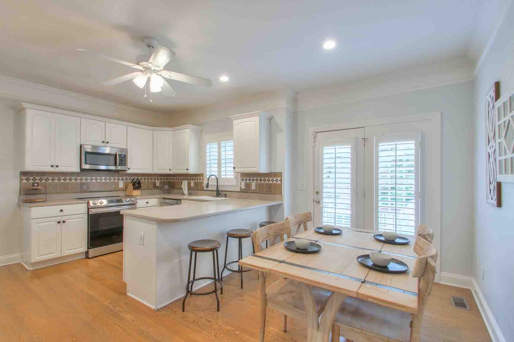 206 Polk Pl Drive Franklin, TN 37064 - Photo 12 of 47 a open dining room with stainless steel appliances granite countertop a stove a sink dishwasher a dining table and chairs with wooden floor