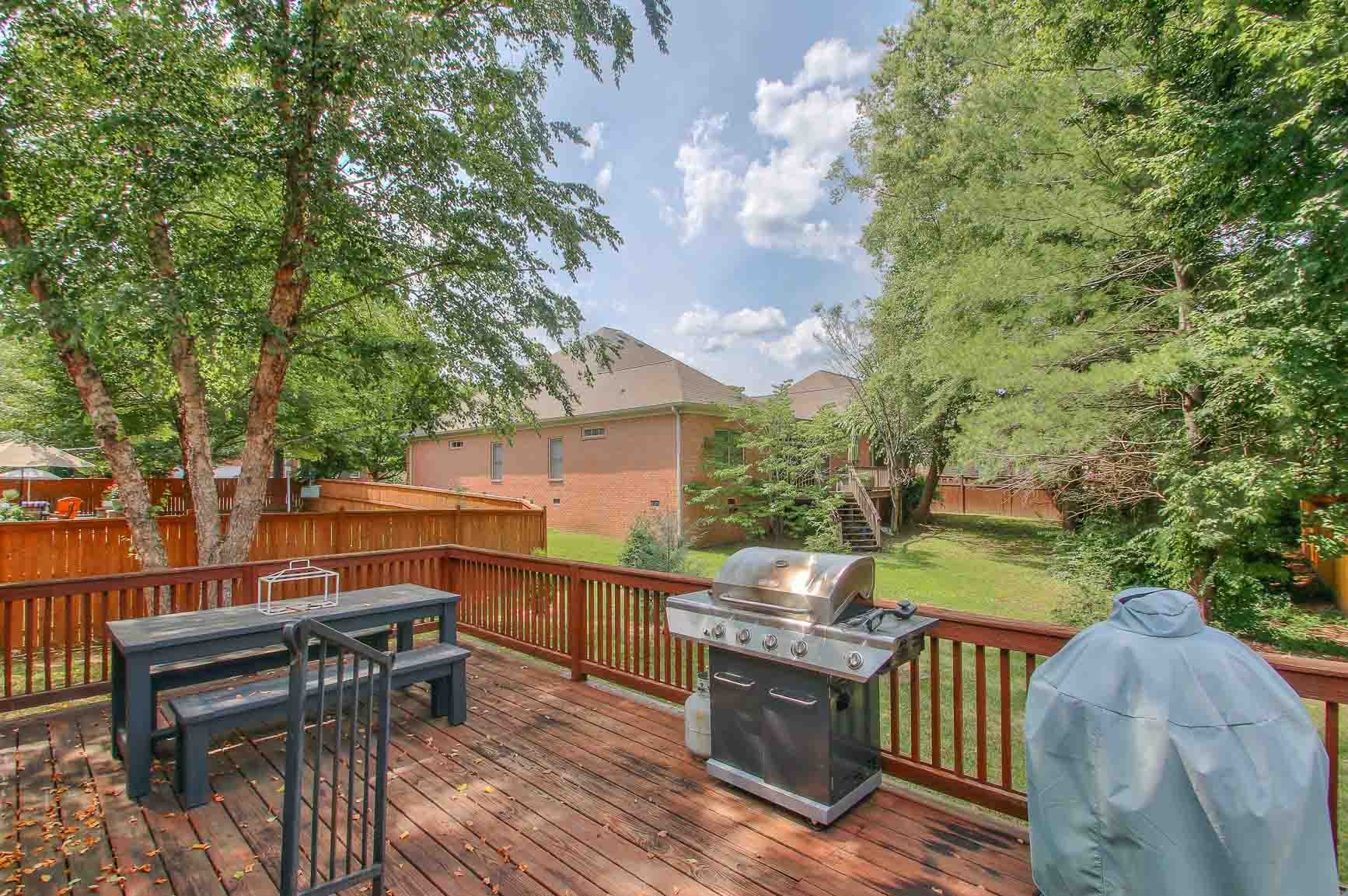 206 Polk Pl Drive Franklin, TN 37064 - Photo 43 of 47 a view of a patio with table and chairs and potted plants with wooden floor and fence