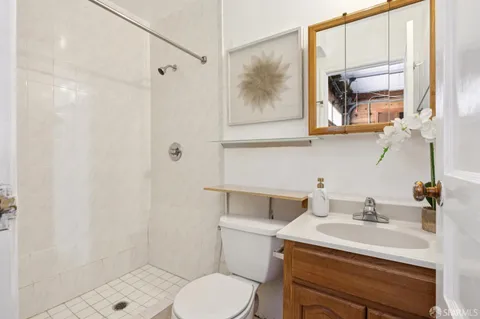 a bathroom with a granite countertop sink a toilet and shower