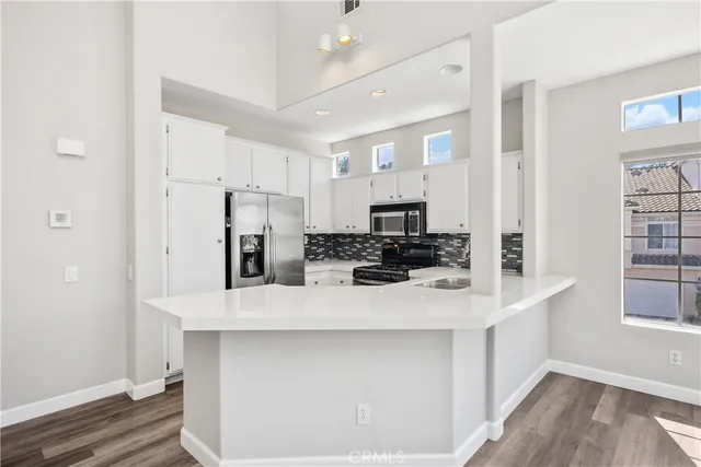 a kitchen with stainless steel appliances a refrigerator sink and microwave