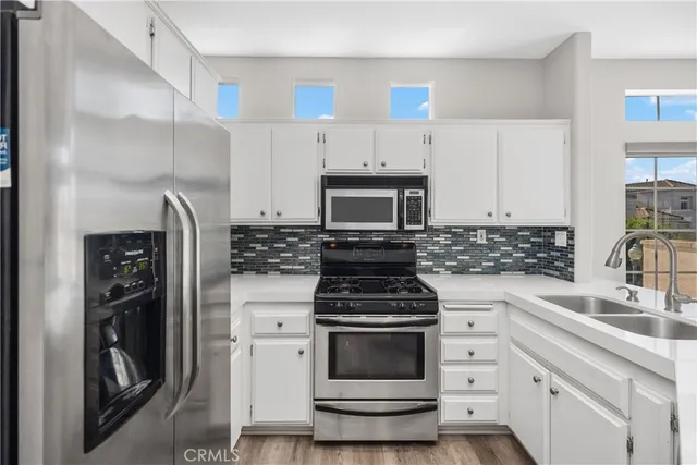 a kitchen with white cabinets and stainless steel appliances