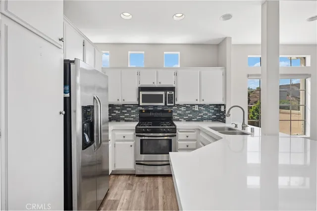 a kitchen with stainless steel appliances granite countertop a refrigerator stove and sink