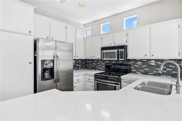 a kitchen with granite countertop a refrigerator and a sink