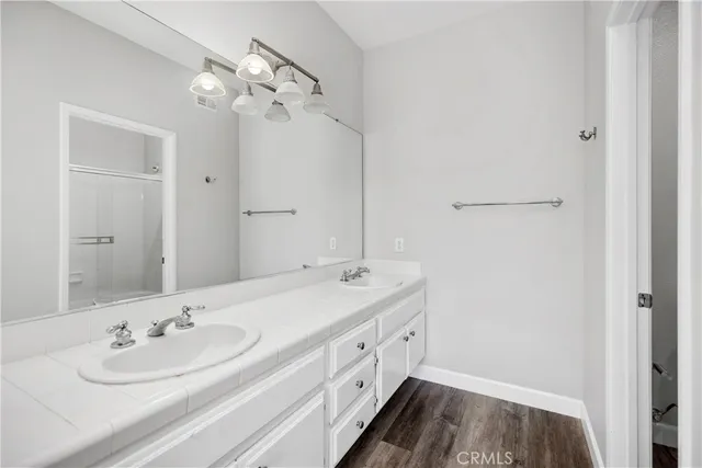 a bathroom with a double vanity sink and a mirror