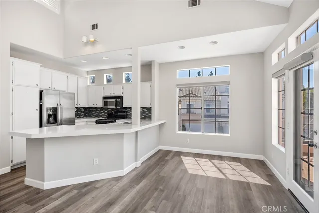 a view of kitchen with stainless steel appliances refrigerator oven and cabinets