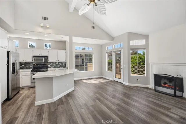 a large kitchen with cabinets wooden floor and stainless steel appliances
