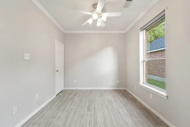 an empty room with a window and a ceiling fan