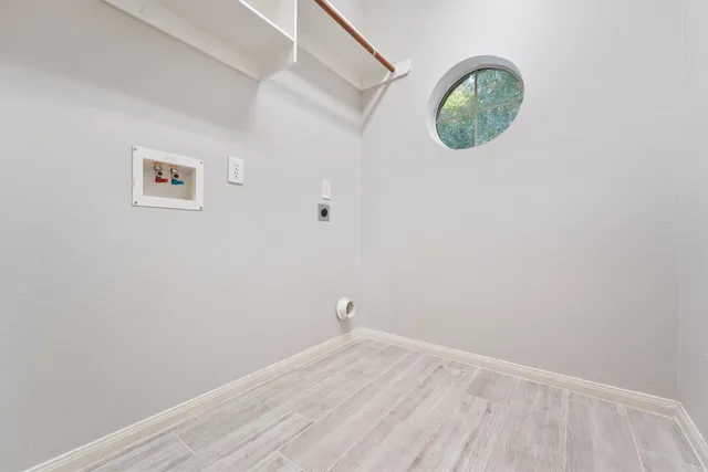 a view of a small space with wooden floor and a window
