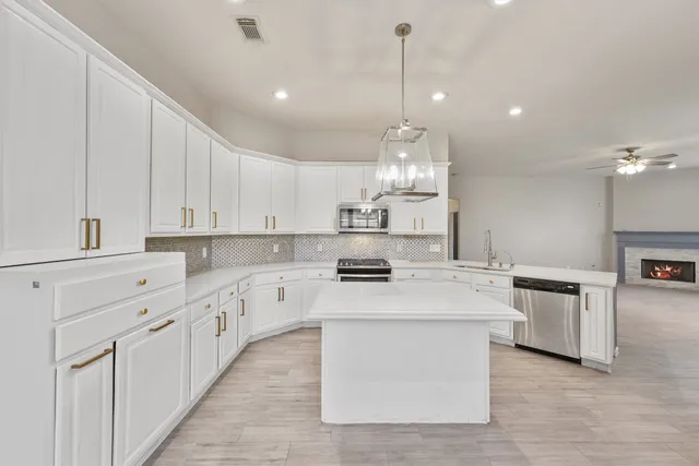 a kitchen with kitchen island granite countertop a sink counter top space and cabinets