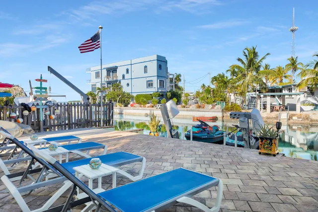 a living room with furniture floor to ceiling window and a flat screen tv