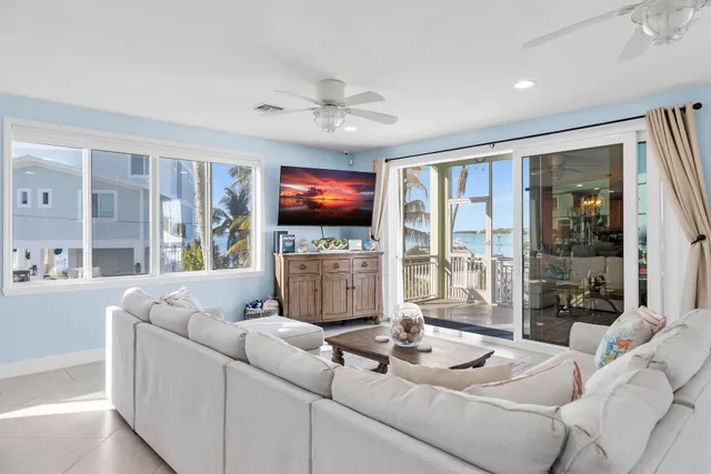 a living room with furniture a flat screen tv and a large window