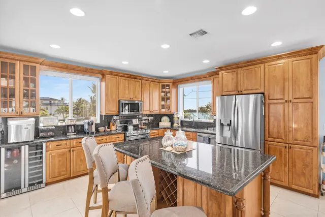 a kitchen with stainless steel appliances granite countertop a sink counter space and living room
