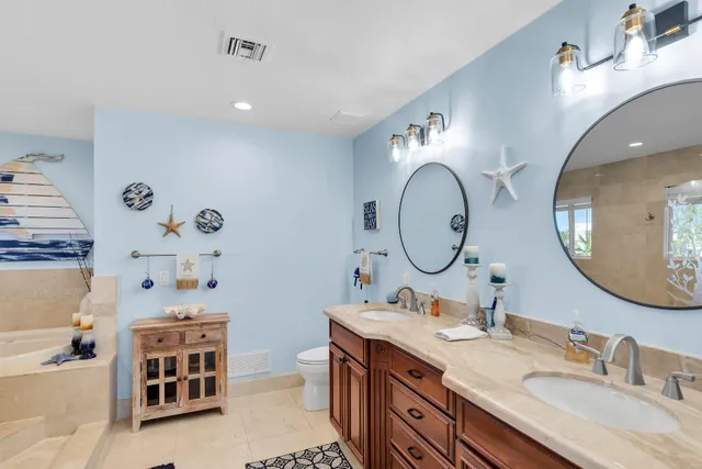 a bathroom with a granite countertop double vanity sink and a mirror