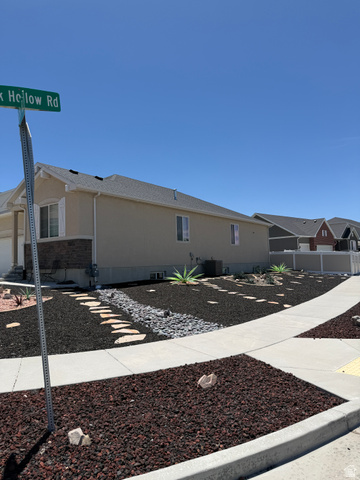 118 Tram Rock Rd. Lake Point, UT 84074 - Photo 2 of 34 Modern xeriscape landscaping featuring dark lava rock, a stone pathway