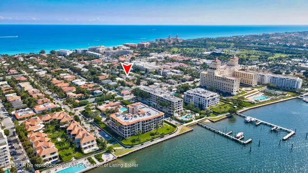an aerial view of a city with lots of residential buildings ocean and mountain view in back