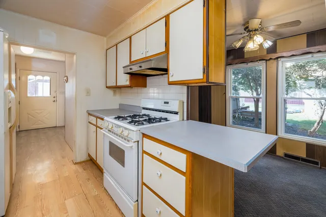 a kitchen with stainless steel appliances granite countertop a stove a sink and a refrigerator