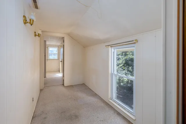 an empty room with closet and chandelier fan