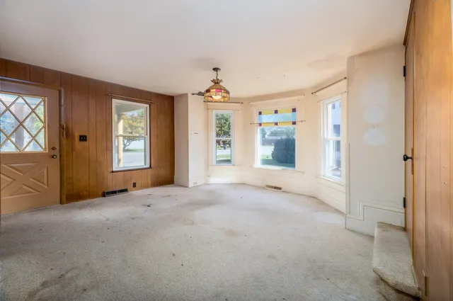 an empty room with windows and cabinet
