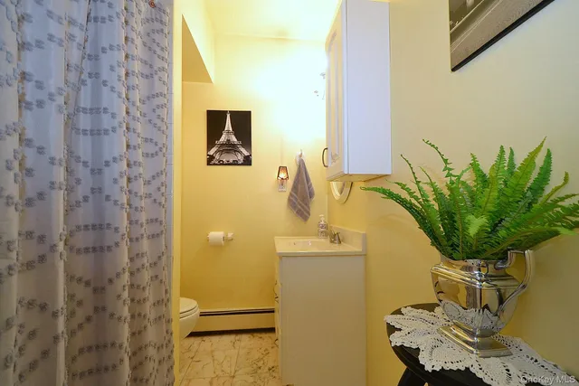 a bathroom with a sink a mirror and potted plant